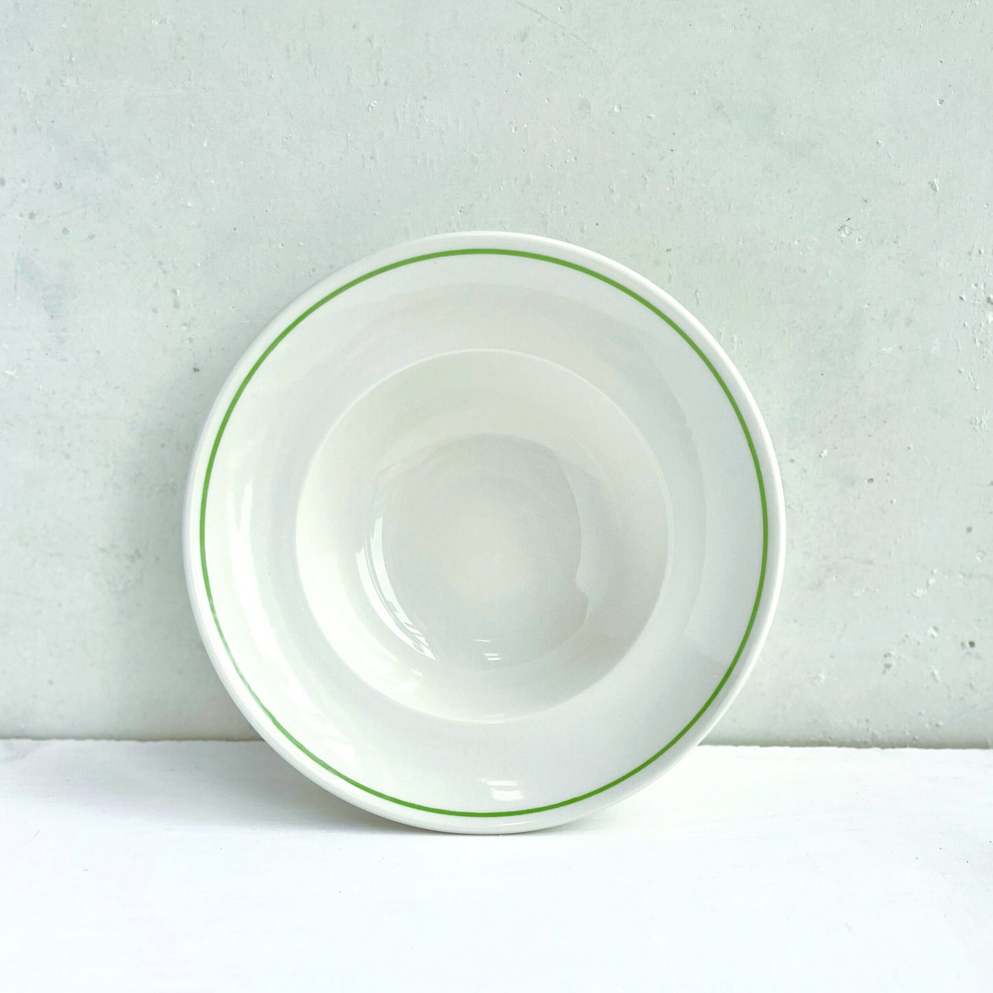 Porcelain Deep Bowl with Clover Green line on rim on a light gray background