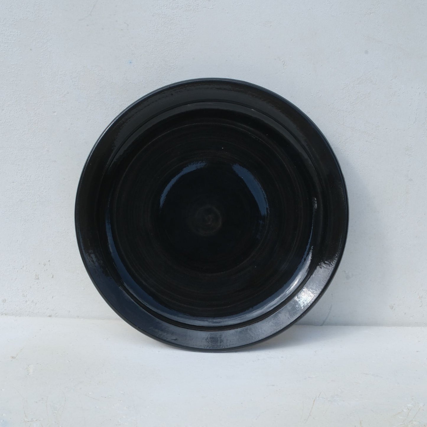 Black ceramic plate on a white background