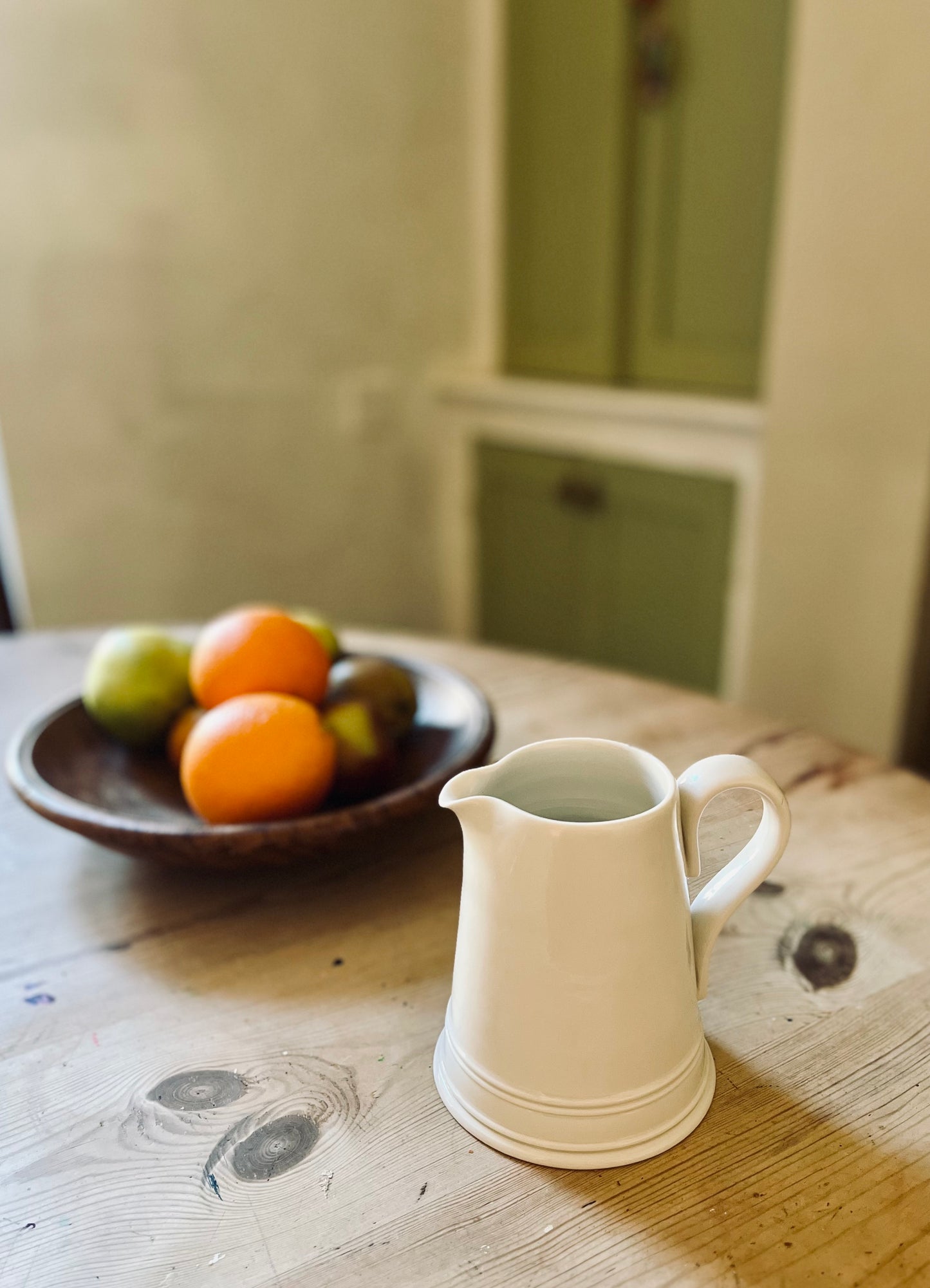 Small Porcelain Dairy Jug on table with fruit bowl