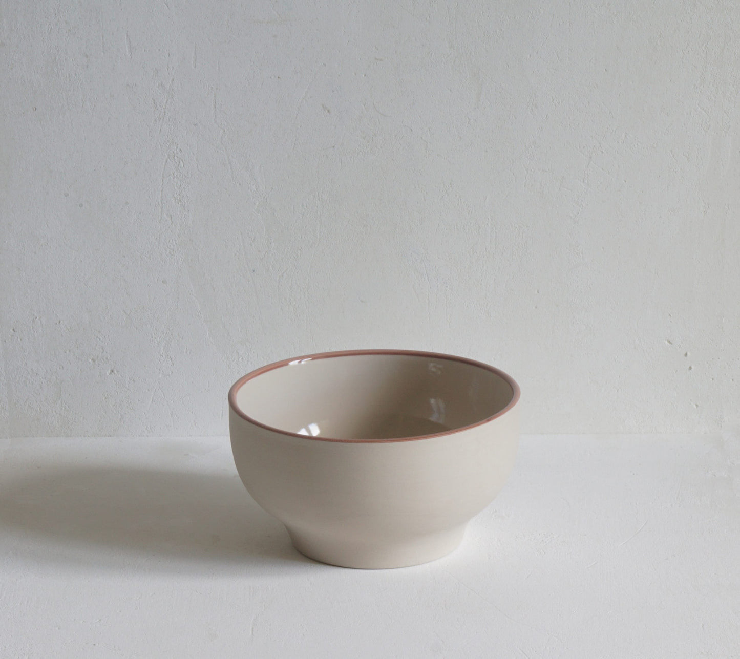 Simple stoneware bowl with hand painted rose pink rim